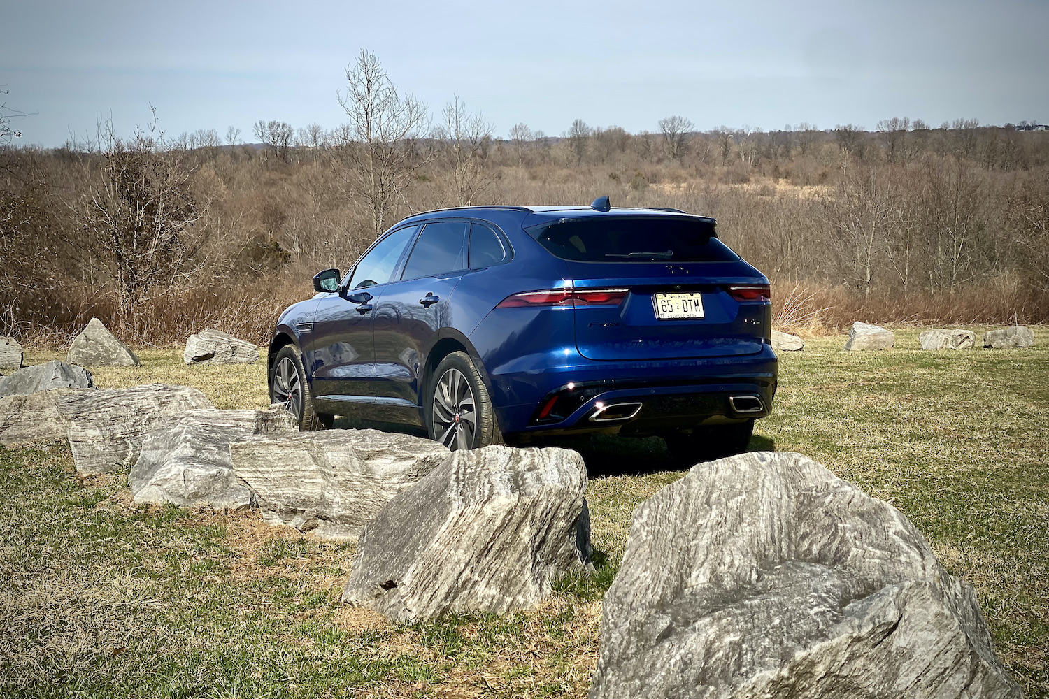 Rear end of 2022 Jaguar F-Pace R Dynamic S with rocks in the forefront.