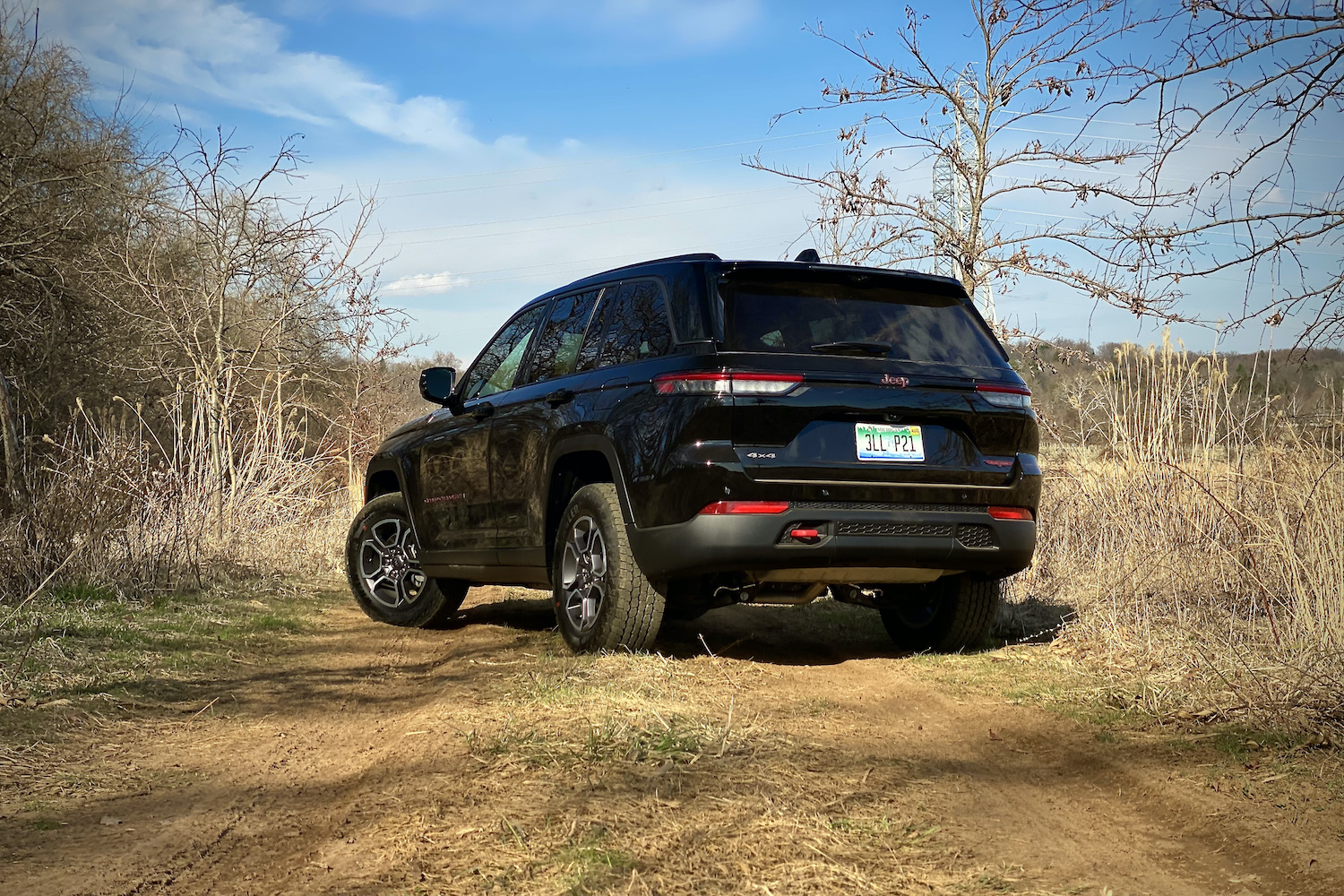 Rear end angle of2022 Jeep Grand Cherokee Trailhawk from driver's side on a dirt trail.