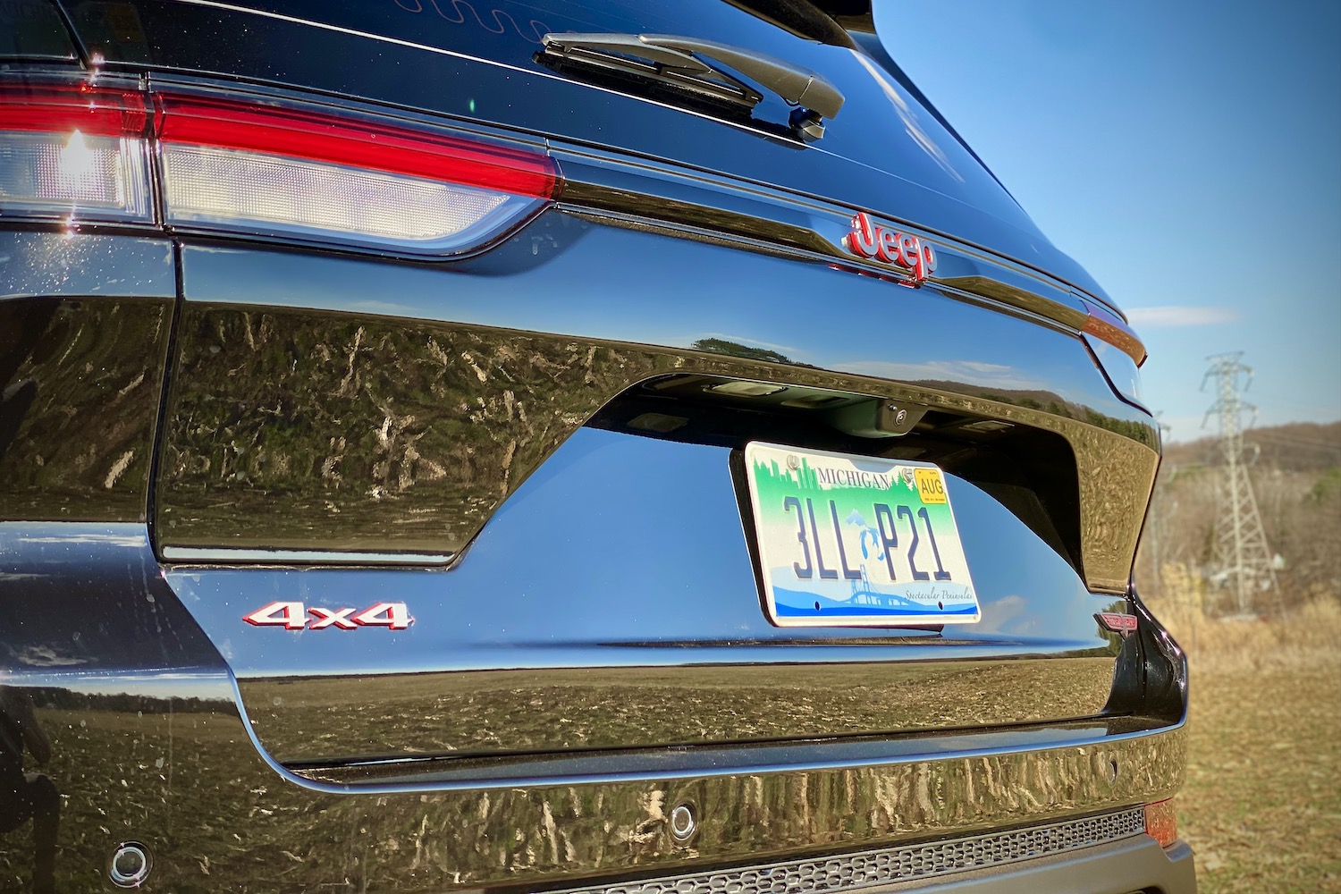 Close up of rear end of 2022 Jeep Grand Cherokee Trailhawk in a grassy field.