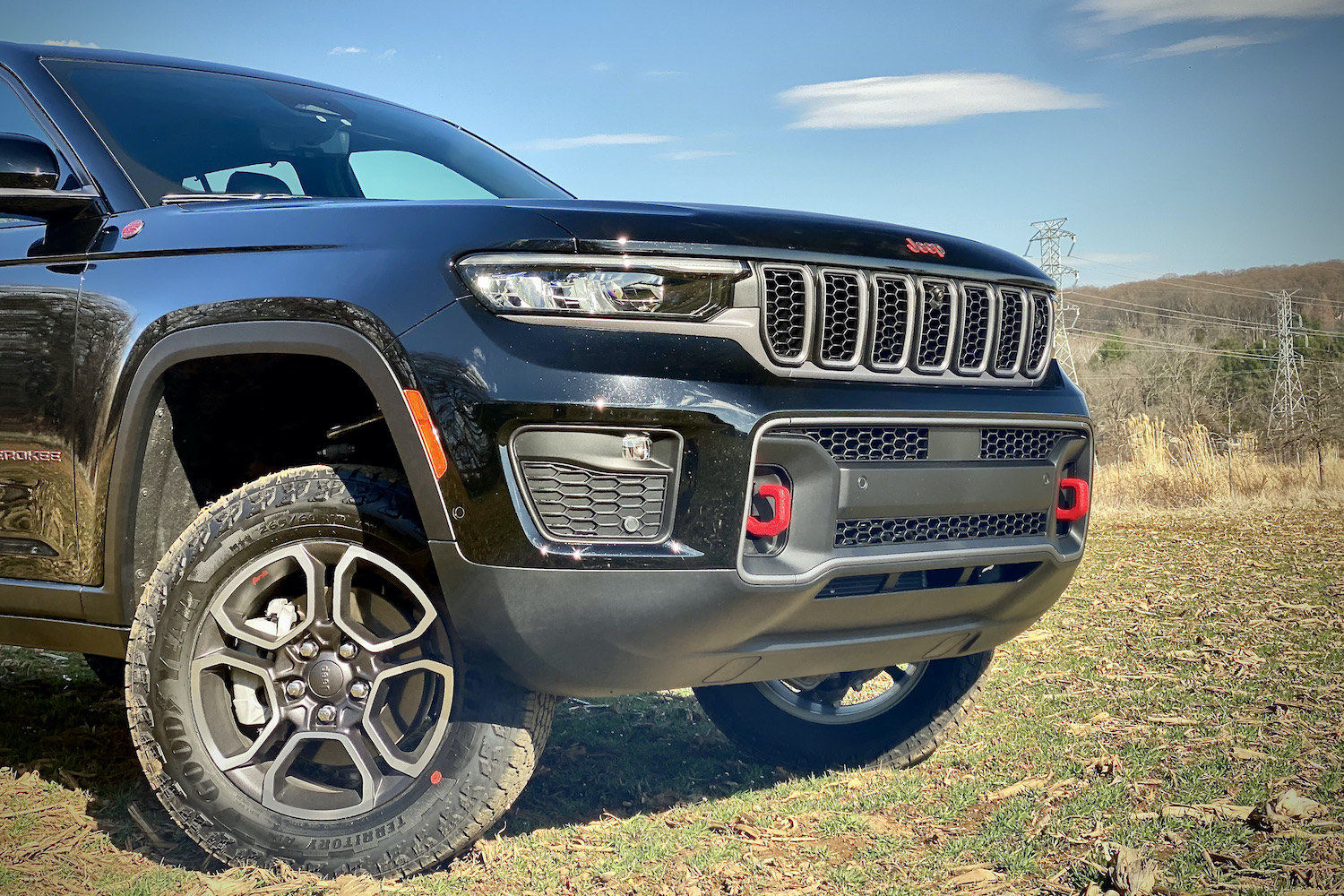 Close up of 2022 Jeep Grand Cherokee Trailhawk front end on a grassy field.