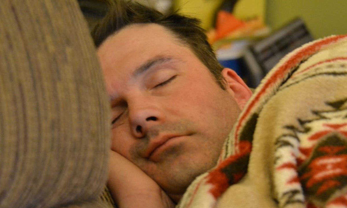 A man sleeps in his bed