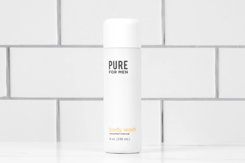 A bottle of Pure for Men Charcoal Body Wash in a bathroom.