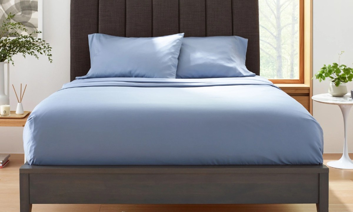 A set of slate blue Clean Design Home x Martex bed sheets on a bed.