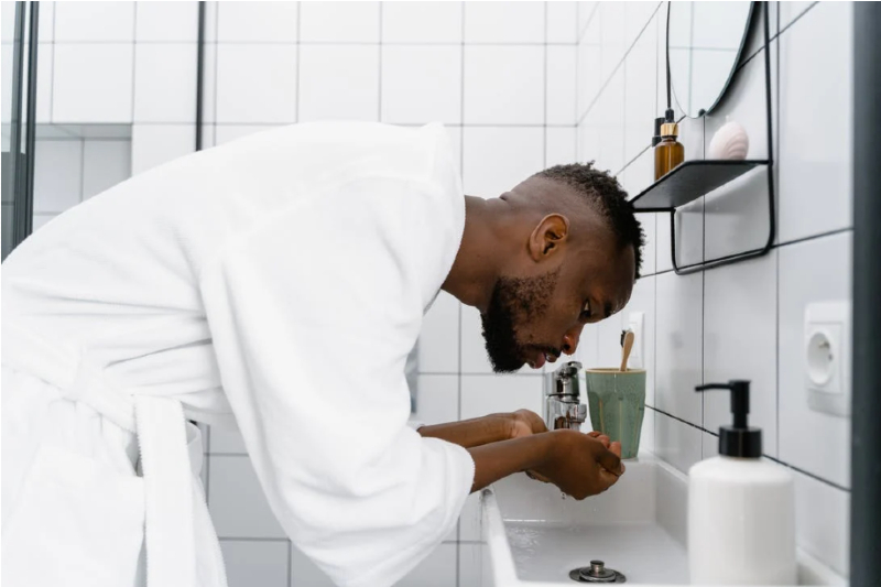 Man washing his face in the bathroom.