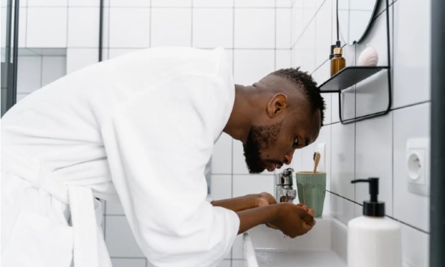 Man washing his face in the bathroom.