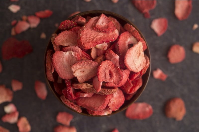 a bowl of sliced and freeze dried strawberries.