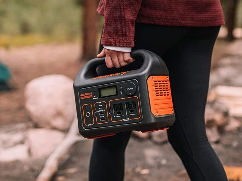 Person holding Jackery Explorer 300 in the woods.
