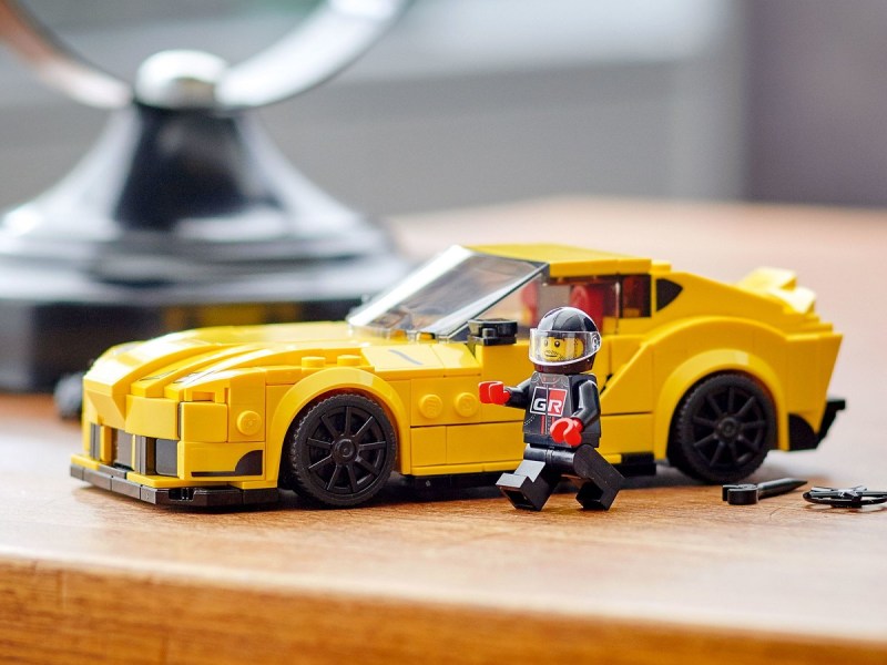 The Lego Toyota GR Supra on a table with a Lego figure.