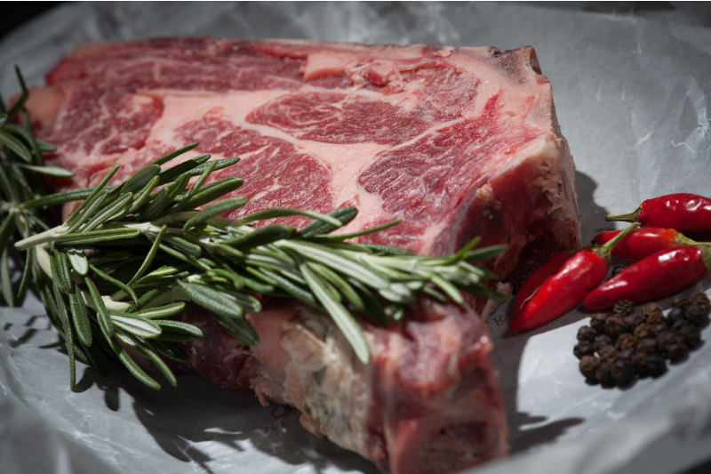 Marbled steak garnished with rosemary.