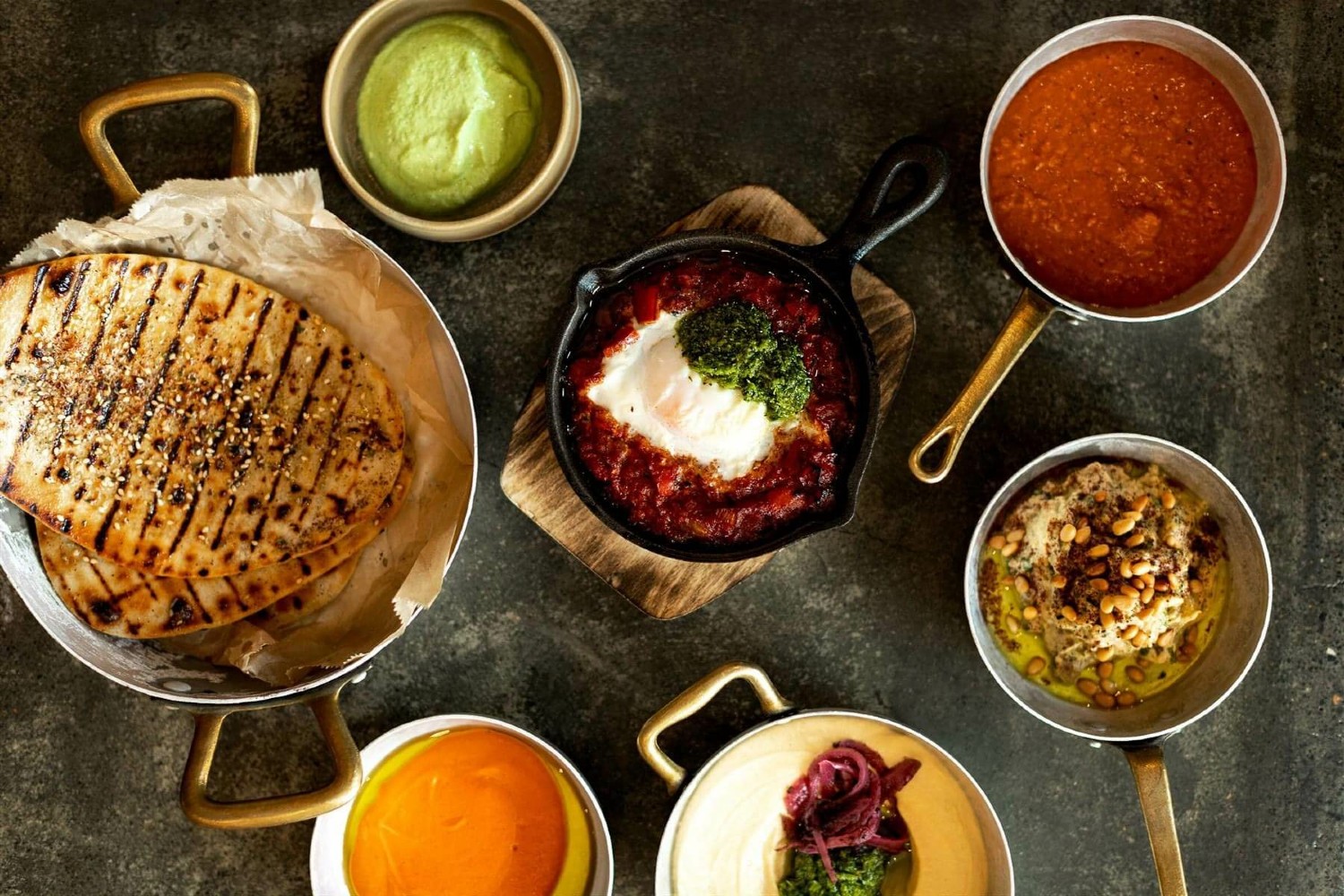 An overhead shot of condiments and dishes on a table.