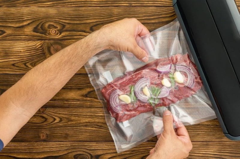 person vacuum packing food.