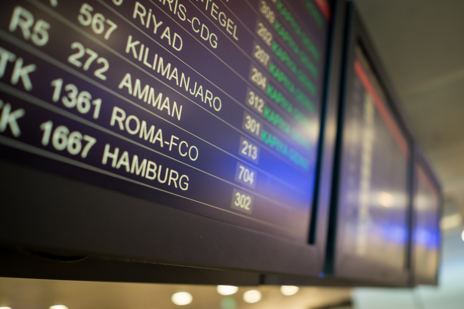 A close-up of a departure screen at an airport terminal.