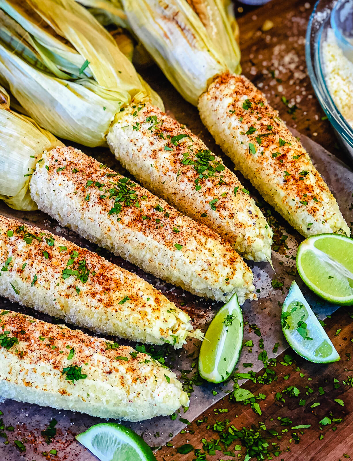 Grilled Mexican street corn with lime slices.
