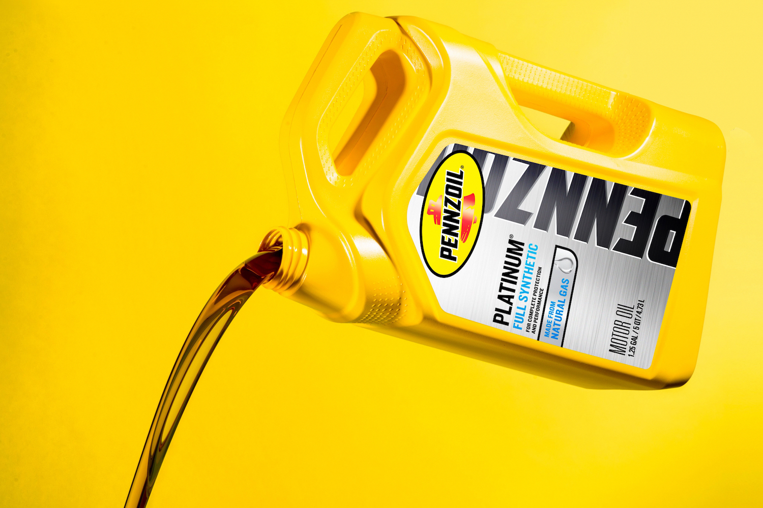 Jug of Pennzoil engine oil being poured out with a yellow background.