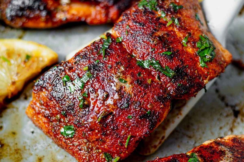 Salmón en una freidora cajún con limón en un plato