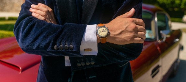 man in a blue velvet jacket wearing a watch.