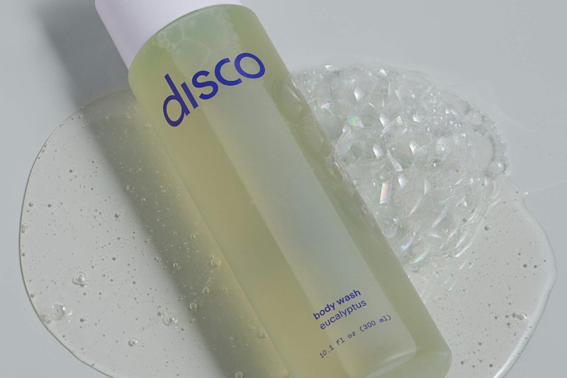A bottle of Disco Invigorating Body Wash in a bathroom.