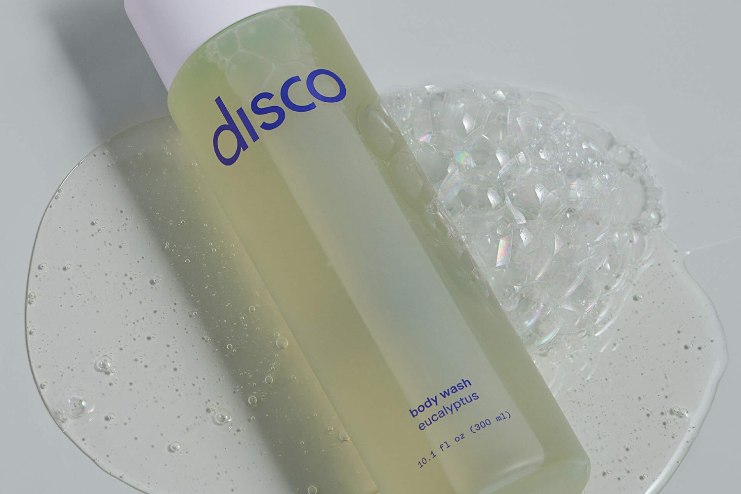 A bottle of Disco Invigorating Body Wash in a bathroom.