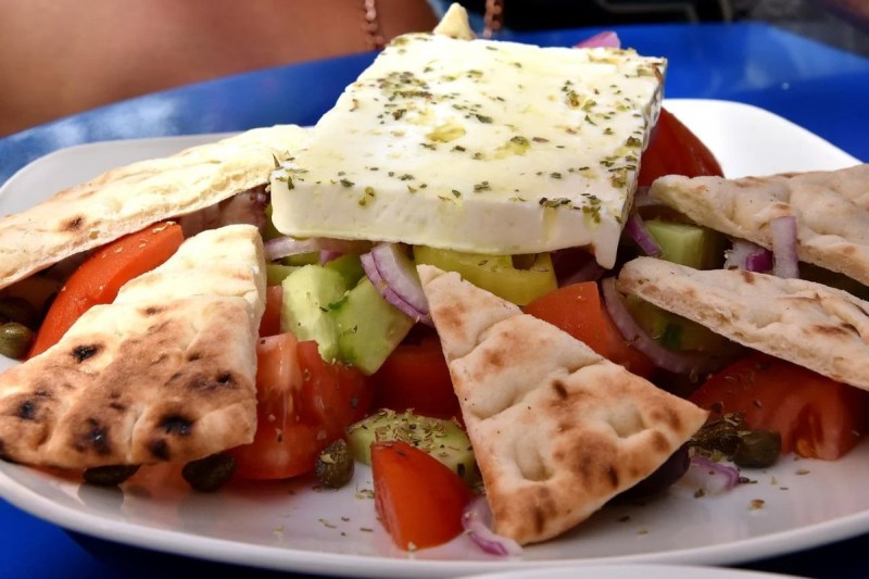 Une salade grecque assaisonnée d'assaisonnement de table grec.