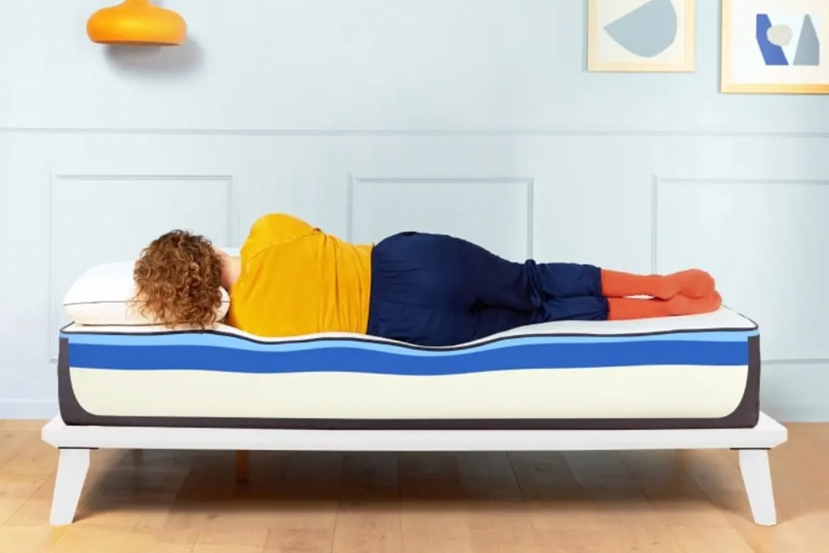A woman rests on a Nectar Memory Foam Mattress.