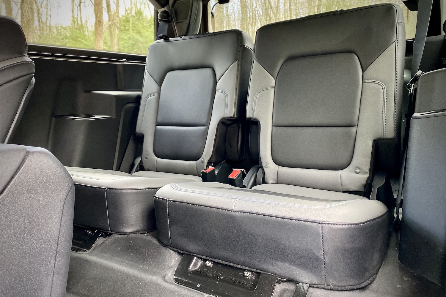 Rear seats in two-door 2021 Ford Bronco with trees in the back.