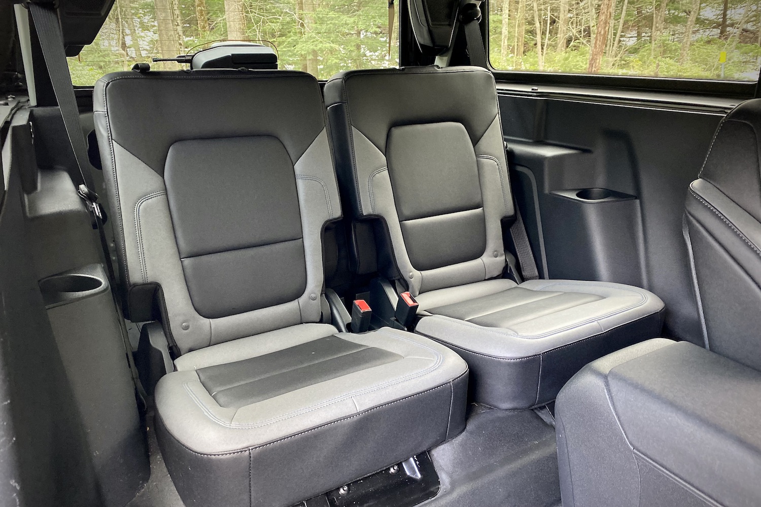 Rear seats in the 2021 Ford Bronco from passenger side outside of the car with trees in the back.