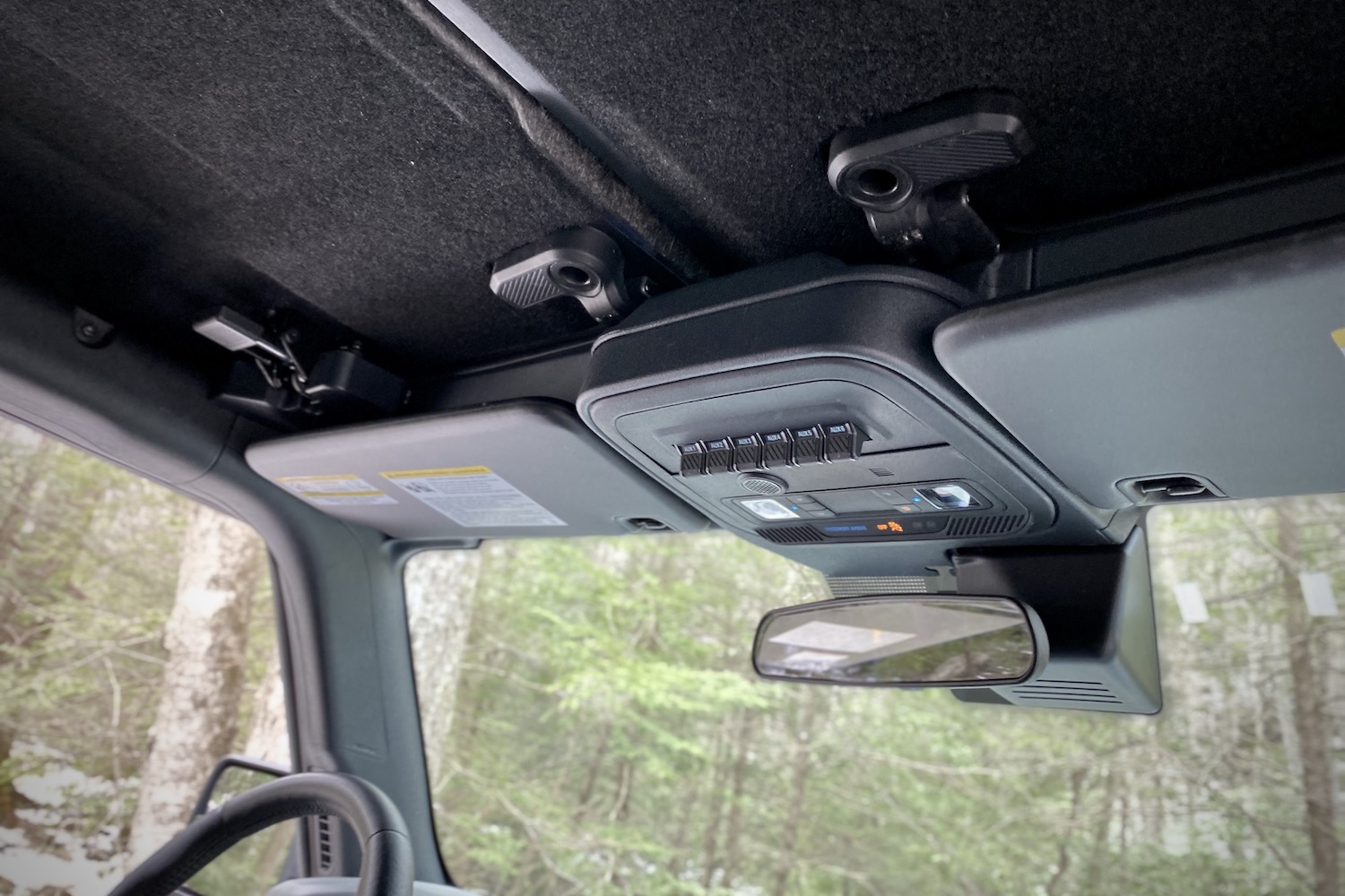 Close up of overhead switches in 2021 Ford Bronco with trees in the back.