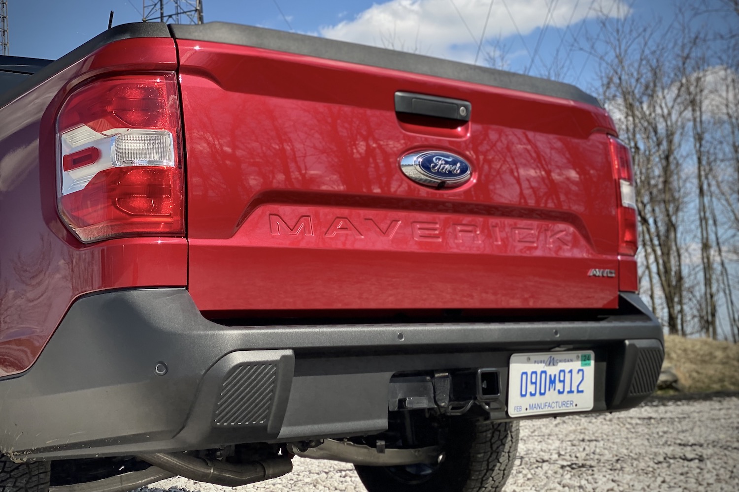 2022 Ford Maverick rear end close up of tailgate and rear badging in a gravel parking lot.