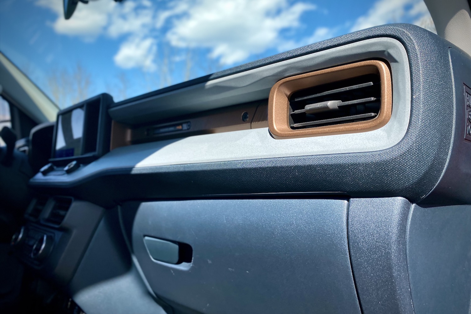Close up of dashboard and front vent in 2022 Ford Maverick with blue skies in the back.