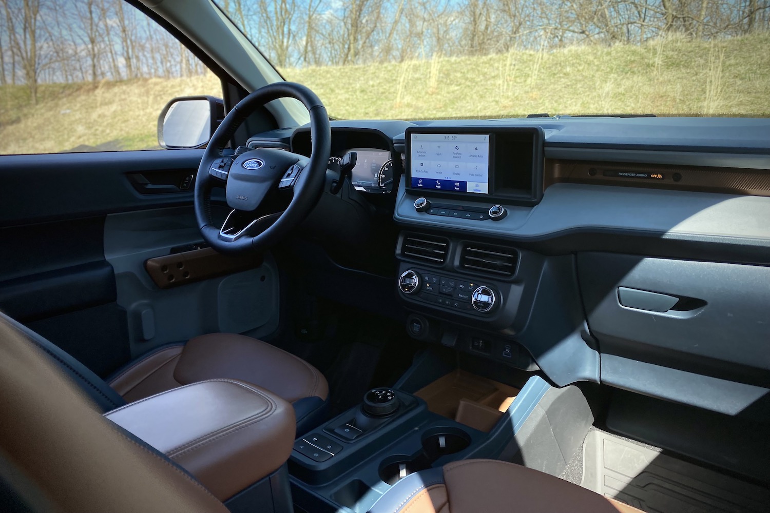 2022 Ford Maverick dashboard and center console from outside the vehicle with grass in the back.