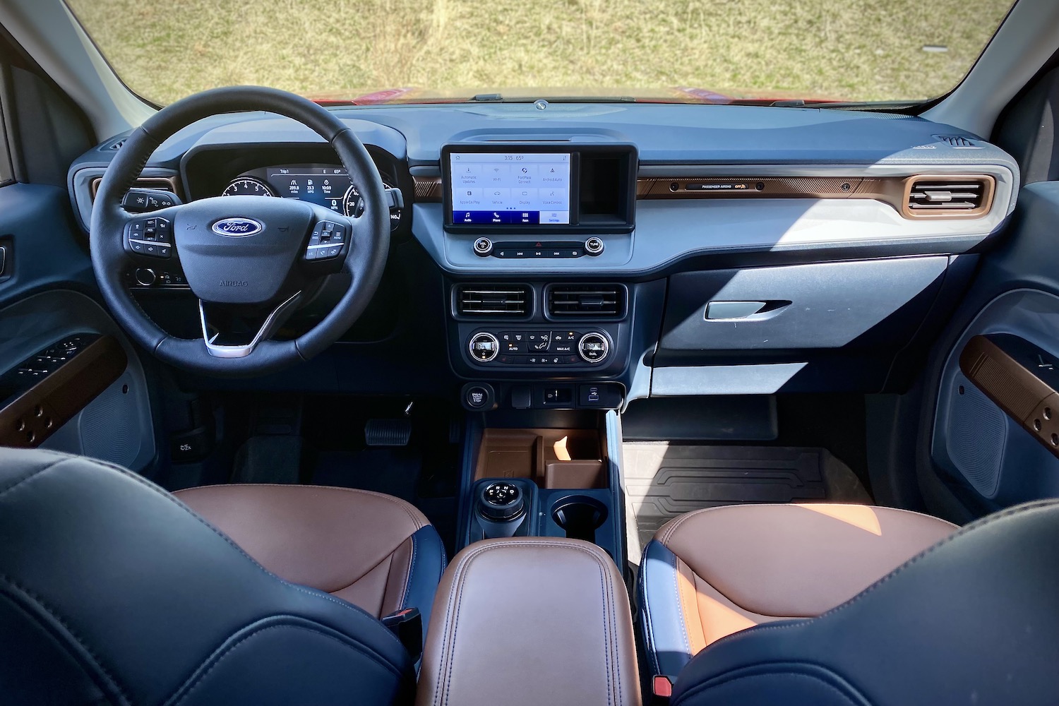 2022 Ford Maverick dashboard and center console with grass in the back.