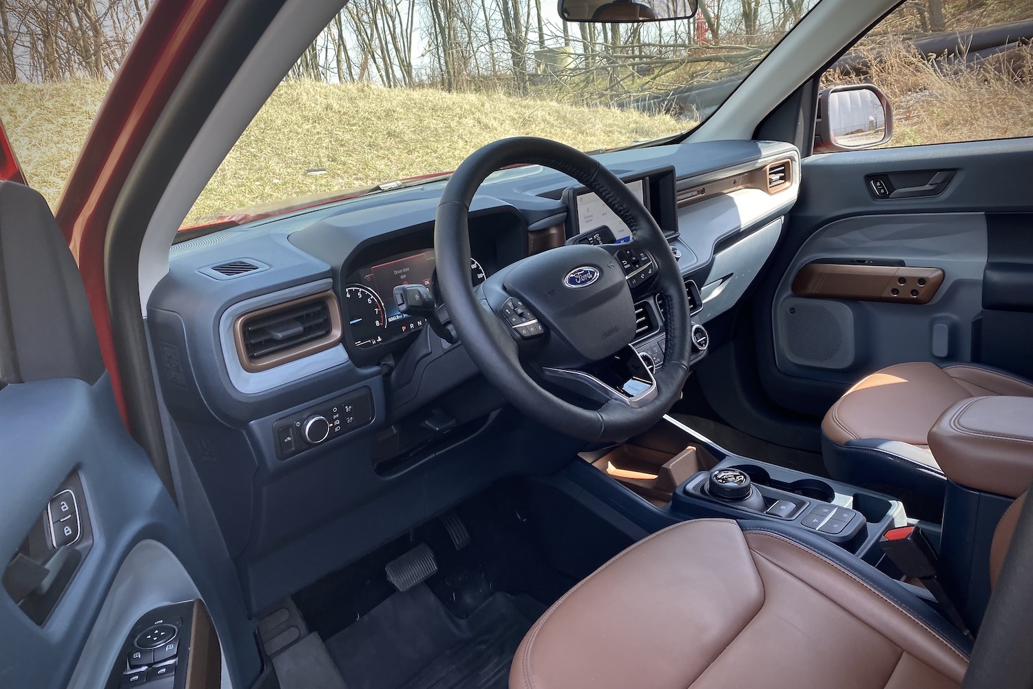 2022 Ford Maverick steering wheel and dashboard from outside the vehicle with grass in the back