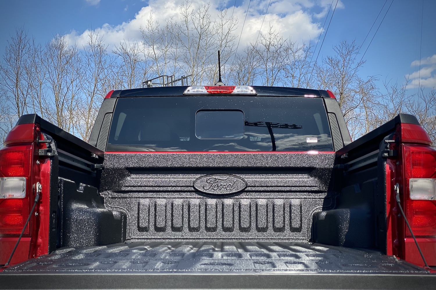 Close up of 2022 Ford Maverick bed from back with tailgate down with blue skies in the back.