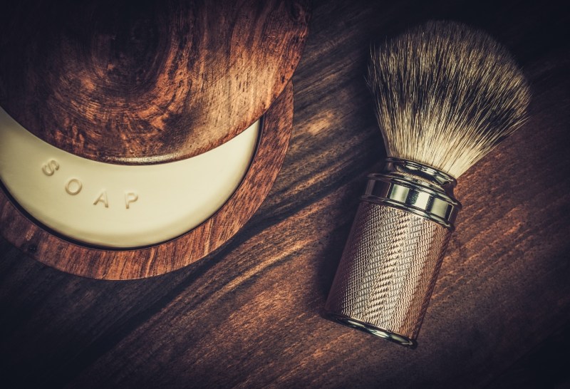 Shave brush and soap on a wooden table.
