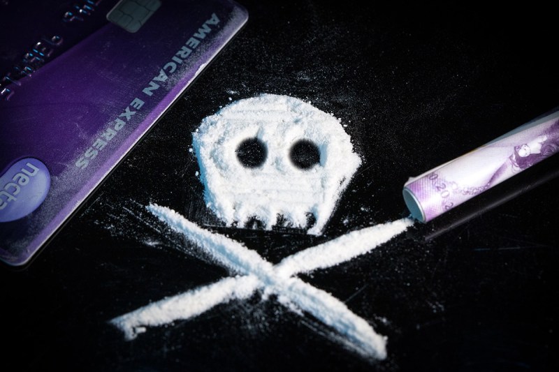 Close-up of a cocaine "skull and crossbones" on a black table.