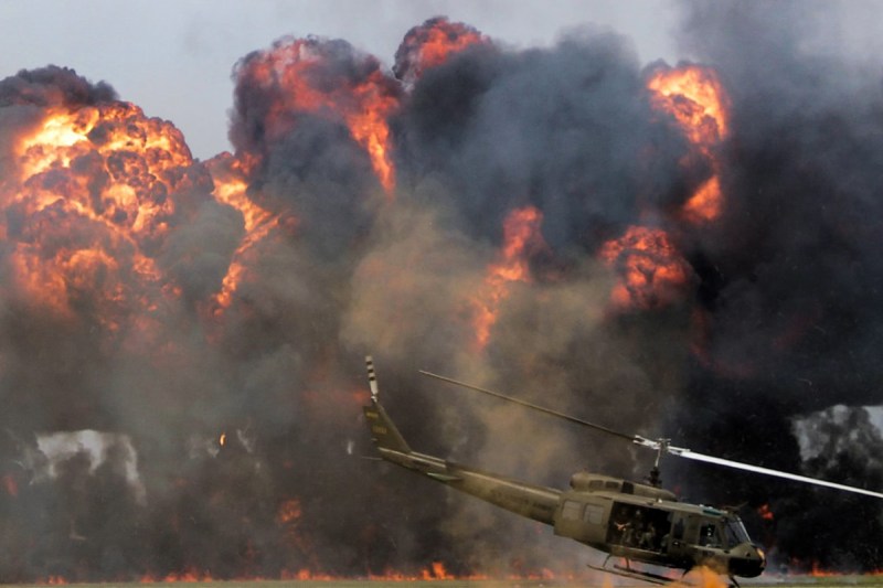 U.S. helicopter dropping bombs on a battlefield.
