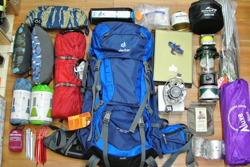 Camping equipment laid out on the ground ready to be packed for a trek