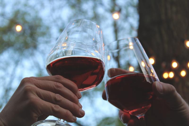 Clinking glasses of red wine