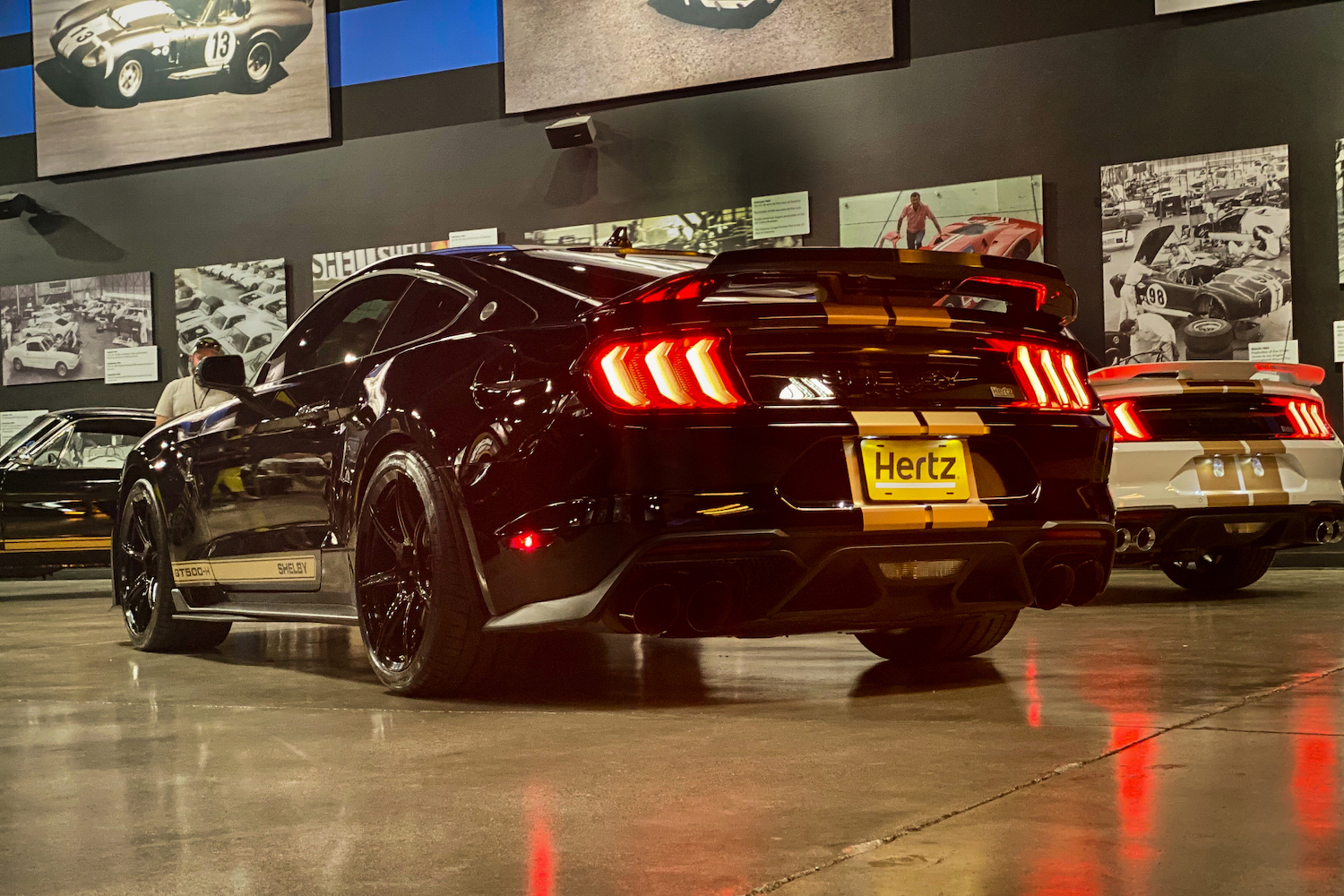 Rear end of 2022 Shelby GT500-H from driver's side with taillights on in a garage.