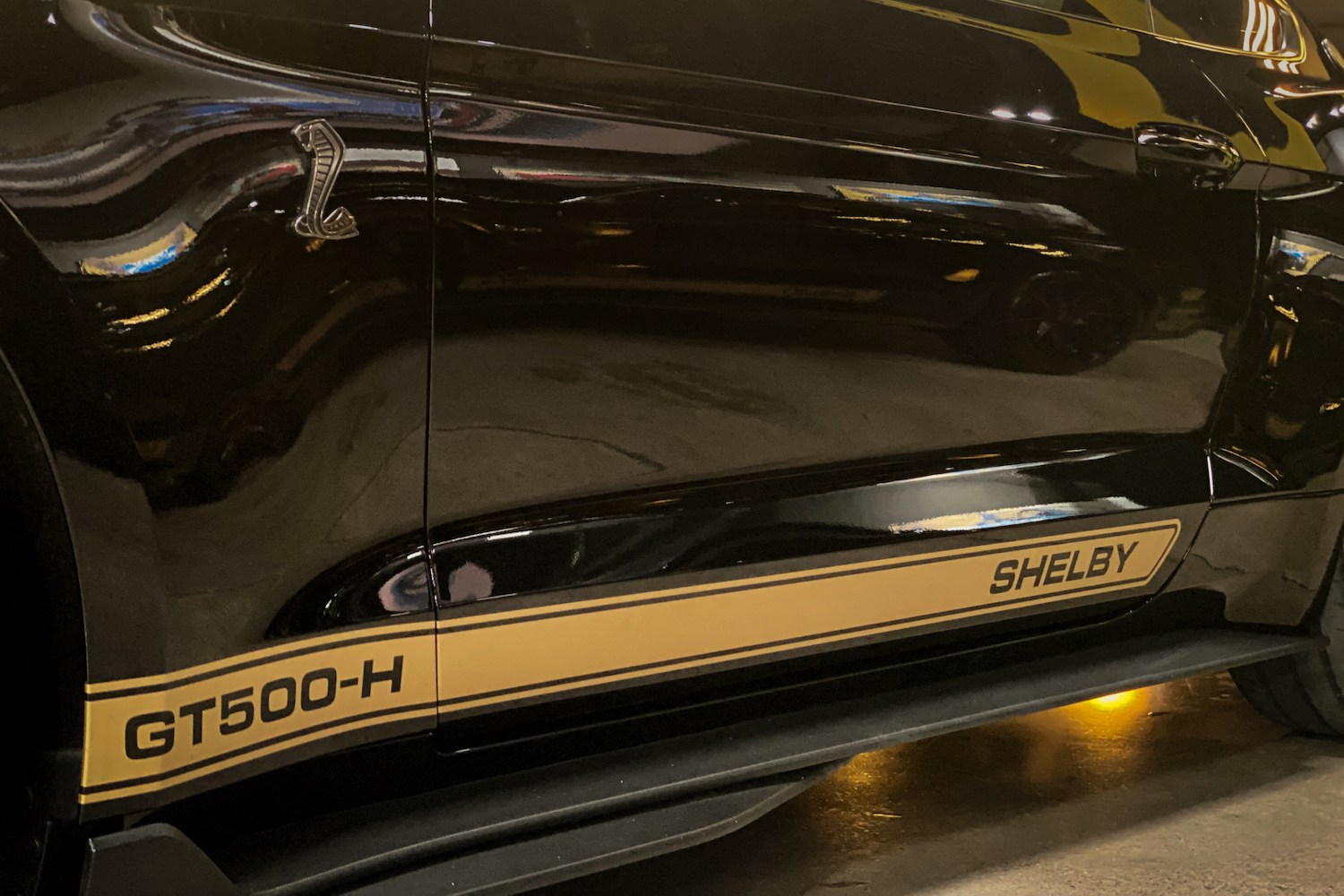 Close up of 2022 Shelby GT500-H rocker panel gold paint strip with GT500-H badges.