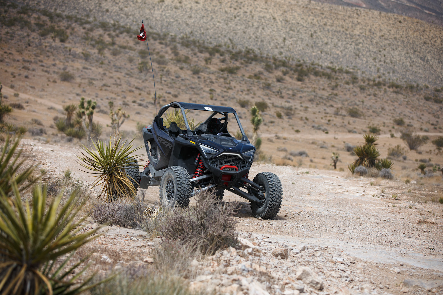 Polaris RZR Pro R in the Mojave desert from the front end on a dirt trail in the desert.