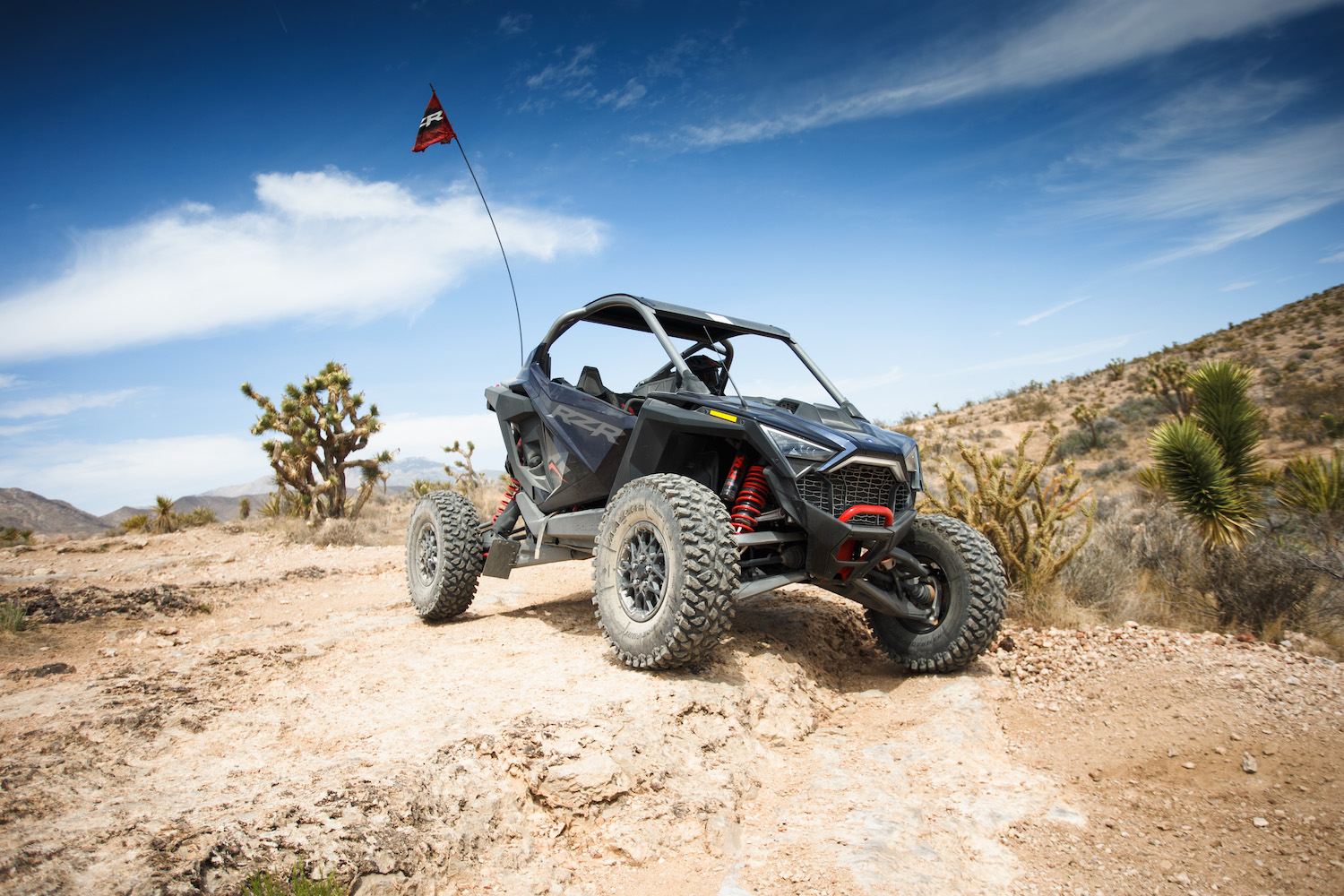Close up of Polaris RZR Pro R driving down a rocky trail in the desert.