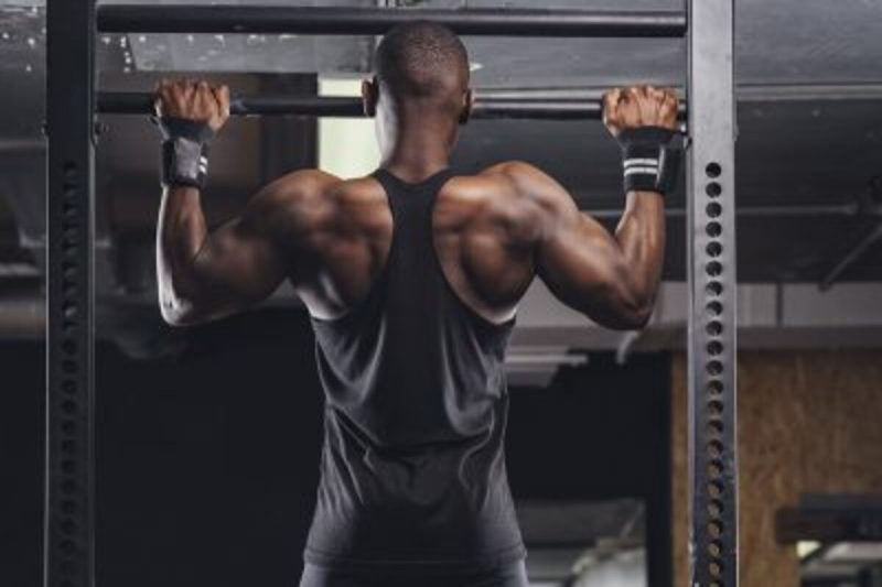 Man doing pullups in a gym.