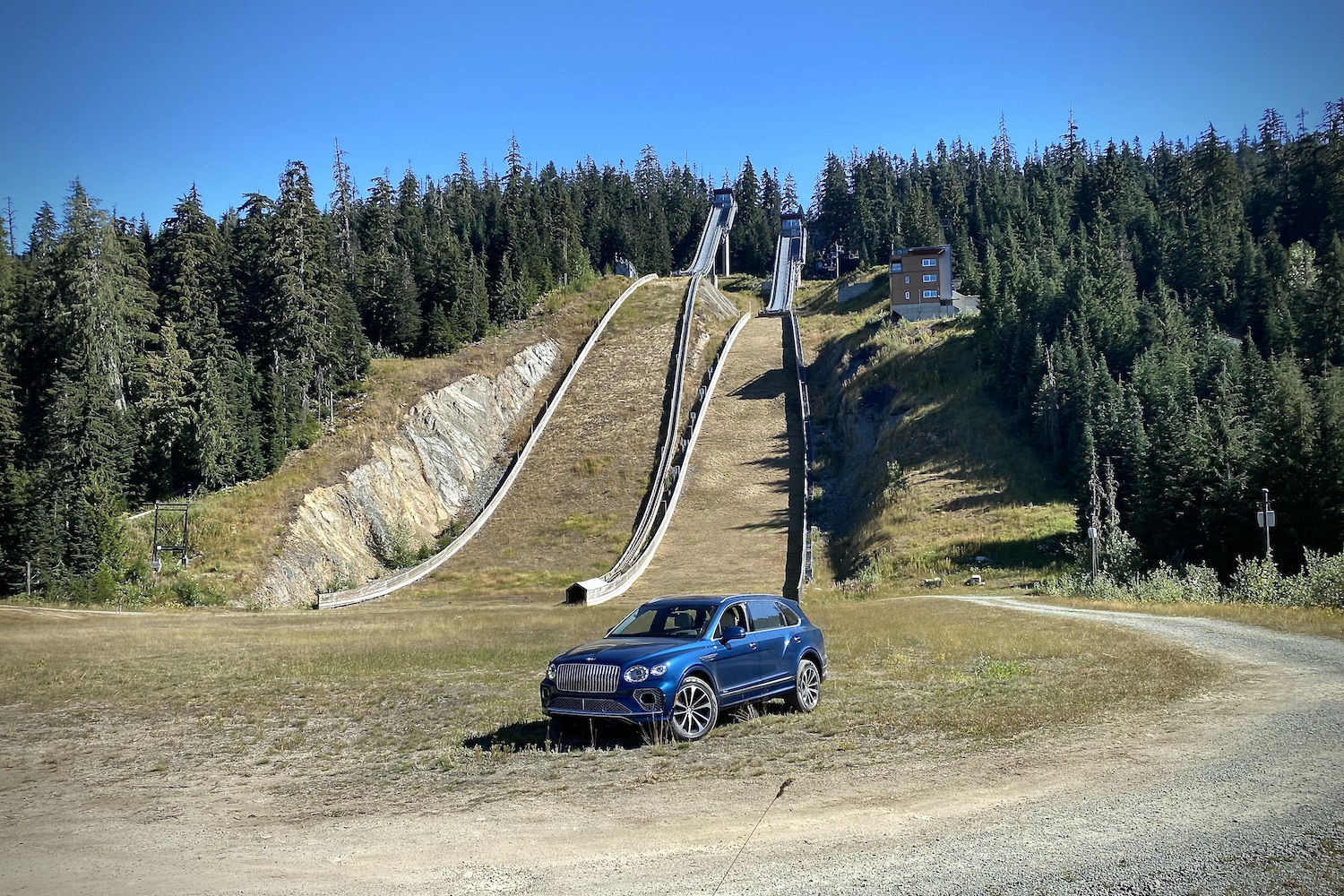 Front end angle of 2023 Bentley Bentayga EWB from driver's side in front of ski jump at Whistler Mountain.
