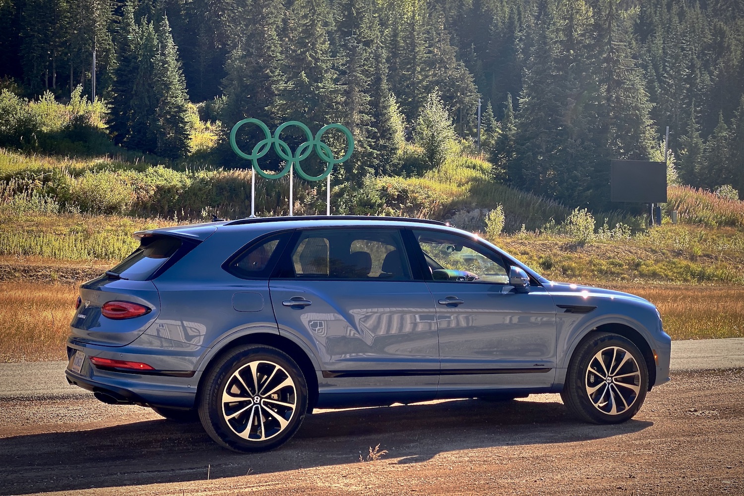 Rear end of 2023 Bentley Bentayga EWB in front of Olympic Sign at Whistler Mountain.