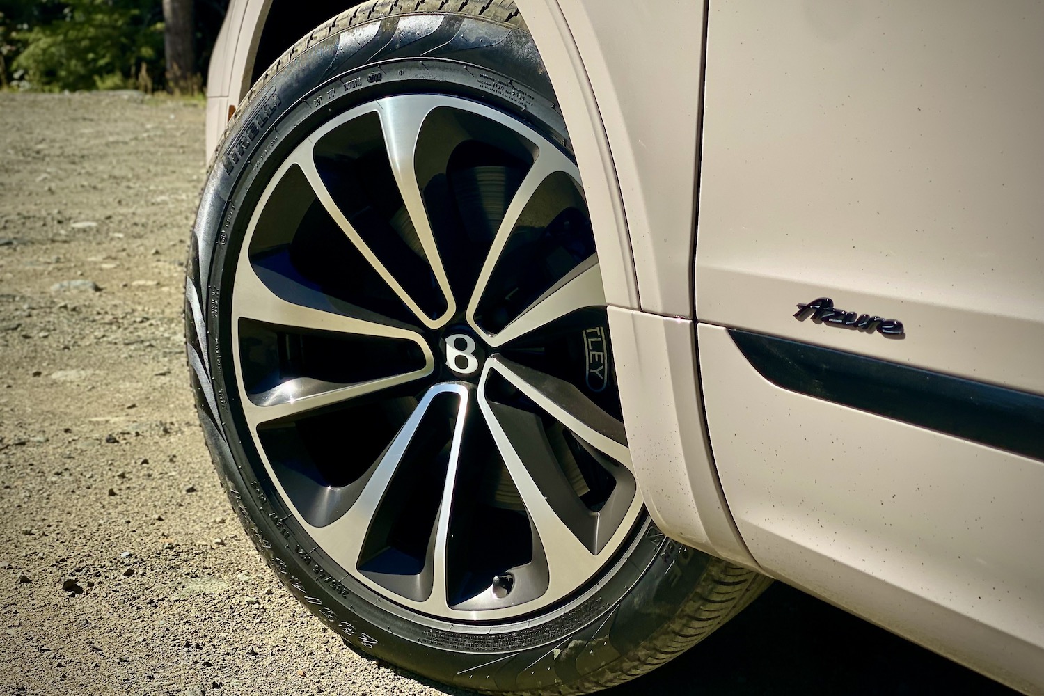 Close up off front wheel on 2023 Bentley Bentayga EWB on a dirt path.