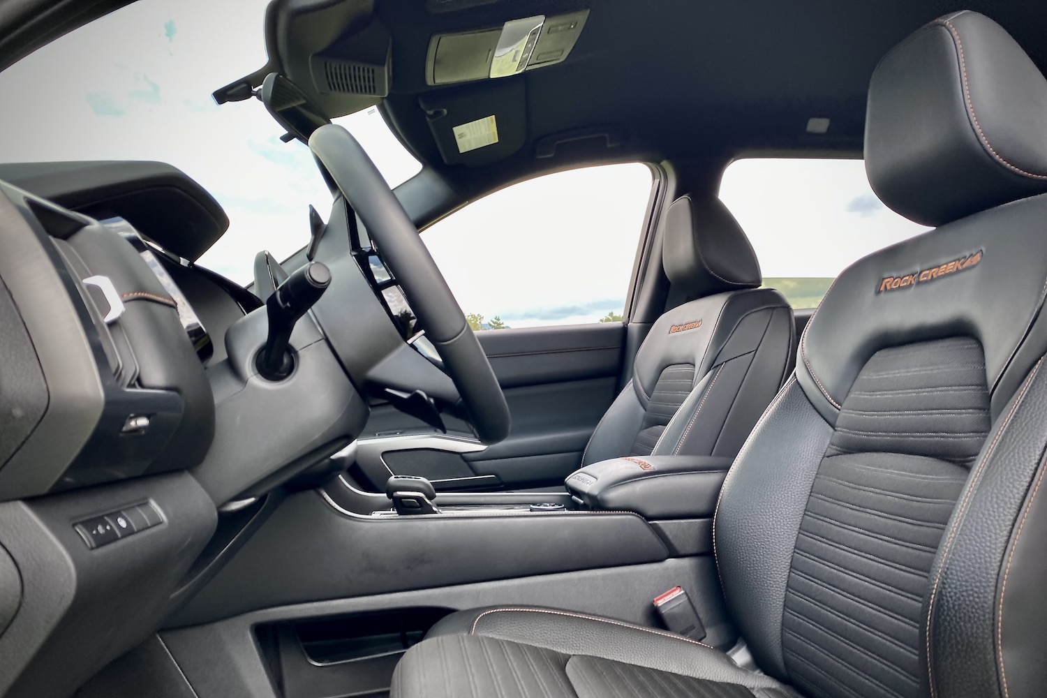 Front seats in the 2023 Nissan Pathfinder Rock Creek from the driver's side with gray skies.