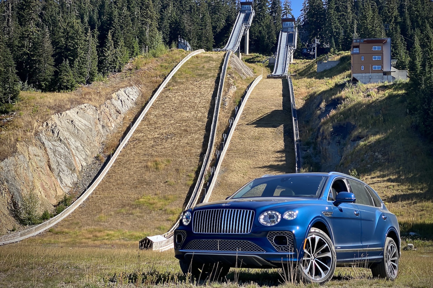 2023 Bentley Bentayga EWB front end driver's side angle in front of ski jumps at Whistler Mountain.