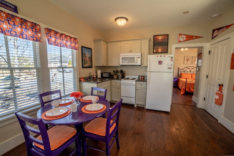 The dining room, kitchen and bedroom of a Clemson Vrbo in purple and orange.