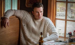 Chris Evans in Knives Out, sitting at a table in a chunky knit sweater